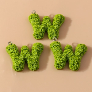 Macro detail of green resin letter W charms with 3D rose textures for DIY jewelry