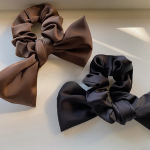 Elegant satin bow scrunchies in black and brown colors with a silky texture finish