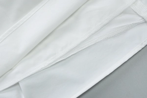 Gros plan détaillé montrant les coutures soignées et le tissu lisse de la robe blanche