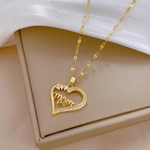 Luxury gold heart Mom necklace with sparkling cubic zirconia on elegant silk background
