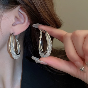 Modern hollow mesh oval silver earrings with polished rings and glitter texture