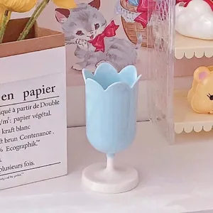 Detail view of light blue tulip storage pot with white round base on desk setup