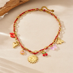 Gold charm necklace with red rope cord featuring sun cherry heart and butterfly pendants