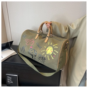 Macro detail of olive green travel bag with colorful hand-drawn doodle patterns and leather trim