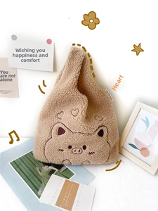 Detailed close-up of brown plush tote bag with cute pig embroidery and heart pattern