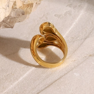 Macro shot of gold organic lava style ring on natural stone showing liquid metal texture