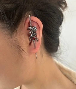 Détail macro d'un piercing industriel tigre argenté sur le cartilage de l'oreille