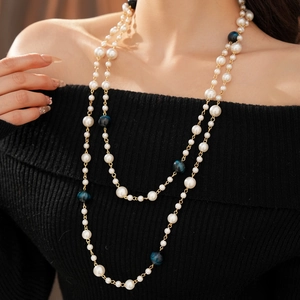 Close-up of double-layer necklace with white faux pearls and blue marbled beads on model