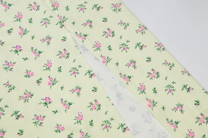 Detail of floral print on light yellow fabric with a high side slit on the dress