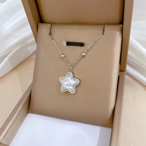 Detail of silver star pendant necklace with mother-of-pearl inlay in a jewelry box
