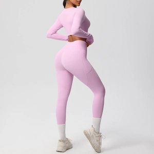 Detail of pink high-waist yoga leggings with functional side pockets and seam contouring
