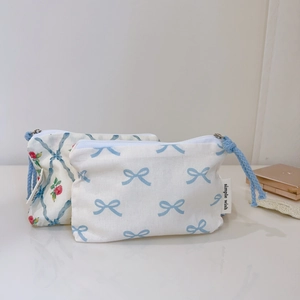 Detailed view of floral cotton pouches with blue ribbons and zip closure