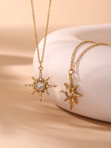 Vue détaillée de deux colliers avec pendentifs étoile dorés et zircons sur céramique blanche