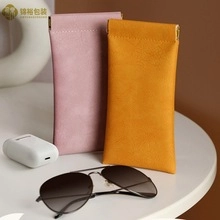 Detail of pink and yellow lychee grain PU leather pouches with squeeze closure mechanism