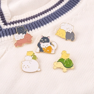 Cute cartoon cat and turtle enamel pins set on a knitted sweater background