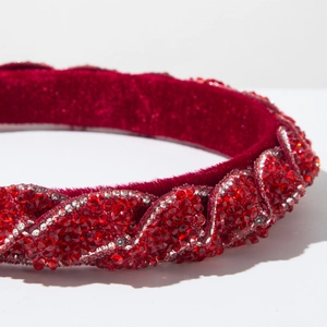 Dettaglio del cerchietto in velluto rosso con strass scintillanti e trama intrecciata