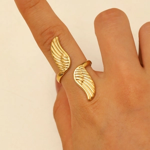 Detailed view of adjustable golden double feather ring on finger with relief texture