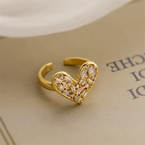 Macro shot of gold-plated heart ring with sparkling white zircon inlay on book pages