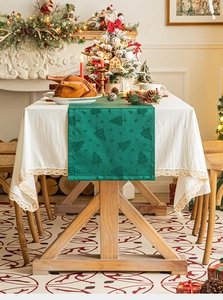 Close-up of green Christmas tree jacquard table runner with delicate lace edges