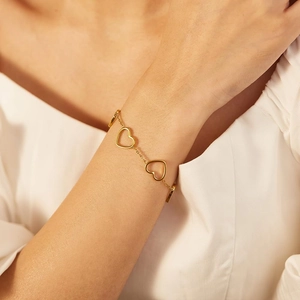 Adjustable stainless steel chain bracelet with gold hollow heart charms worn on a wrist