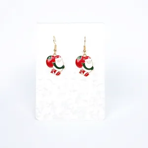 Detail of Santa Claus earrings with red gift bag design in festive red and gold colors