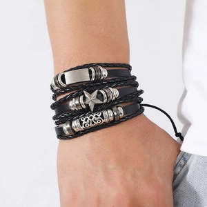 Close-up of a layered leather bracelet with a silver star charm and hollow patterned bead