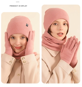 Detailed view of pink knitted winter set with warm hat, scarf and matching gloves