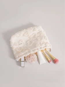 White plush heart cosmetic bag with soft texture and diverse makeup storage essentials