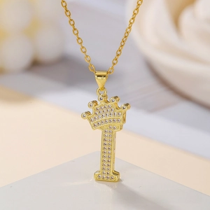 Macro shot of gold crown pendant with letter T featuring micro-pave white zircon stones
