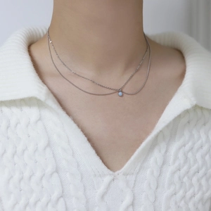 Close-up of double-layered silver titanium necklace with a round baby blue opal stone