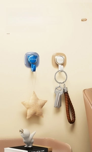 Detail of cartoon bear-shaped adhesive hooks in navy and cream with golden metal hooks