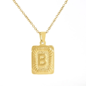 Close-up of 18K gold plated rectangular pendant with embossed letter B and radial pattern