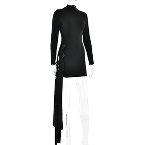 Détail de mini-robe noire à manches longues avec nœud latéral et longue bande fluide