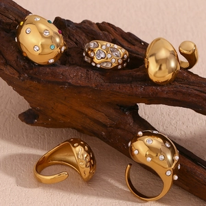 Detailed view of textured gold rings with sparkling rhinestones and colorful gemstones