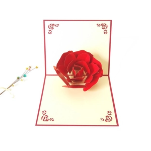 Detail of 3D pop-up red rose greeting card with laser-cut petals and cream-colored insert