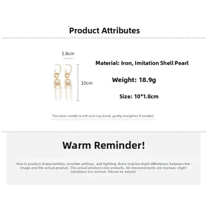 Detail view of gold tassel earrings with imitation pearls and size measurements