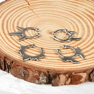 Minimalist silver stainless steel U-shaped fake nose rings and punk ear cuffs on wood