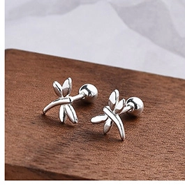 Macro view of dragonfly silver stud earrings with screw-back ball and detailed texture