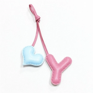 Dettaglio di un cuore in pelle azzurra e lettera Y rosa per ciondolo da borsa moda