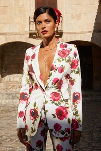 Gros plan d'un blazer blanc et d'un pantalon avec imprimé rose rouge sur un mannequin