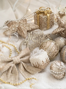 Festive gold and silver Christmas ornaments with Merry Christmas sign on white snow