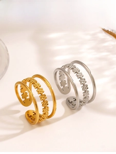 Detail of multi-layer stainless steel ring with open clover patterns and polished finish