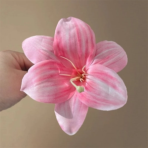 Macro shot of a pink and white artificial lily hair clip with fabric petal texture