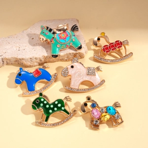 Collection of colorful rocking horse brooches with enamel and inlaid crystals on warm background