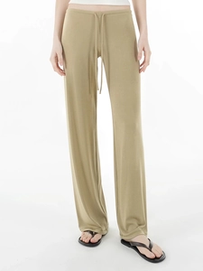 Detail of khaki wide-leg drawstring trousers showing drape and breathable fabric texture