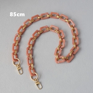 Detail of 85cm pink-orange resin bag strap with gold metal rings and lobster clasps