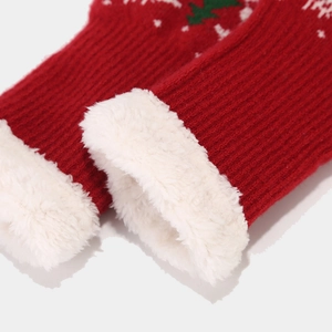 Detail of red Christmas knit gloves showing thick white faux fur lining and festive pattern