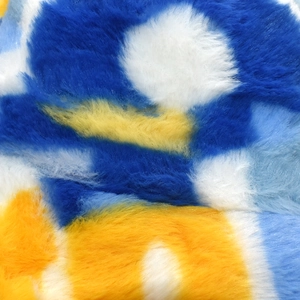 Gros plan sur le tissu en fausse fourrure pelucheuse aux motifs abstraits bleu et jaune