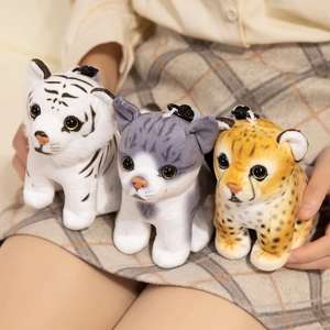 Three plush animal pendants featuring tiger and leopard designs on a grid background