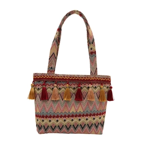 Ethnic bohemian woven tote bag with colorful fringe and geometric patterns in pink and beige